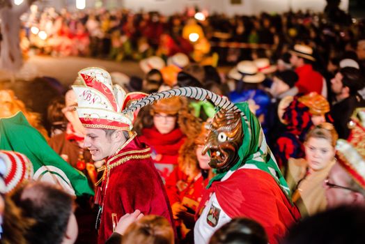 NEUHAUSEN, GERMANY ��� MARCH 4, 2014: Masked people are celebrating the end of carnival (fasnet) season by burning a puppet that is wearing a traditional costume (called the ���H��s���) symbolizing carnival on March 4, 2014 in Neuhausen (near Stuttgart), Germany. Carnival has a very long tradition in Neuhausen with influences of the swabian alemanisch culture that can be seen by the wooden masks people are wearing as part of their costumes.