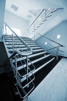 Marble staircase with a steel handrail in a modern building