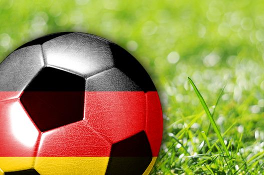 Soccer ball on grass with flag of Germany painted on it