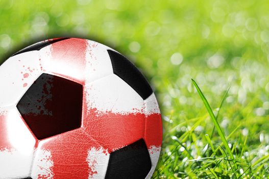 Soccer ball on grass with flag of England painted on it