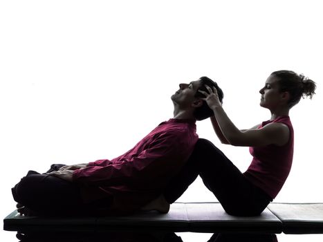 one man and woman performing thai head massage in silhouette studio on white background
