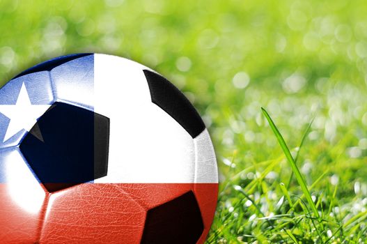 Soccer ball on grass with flag of Chile painted on it