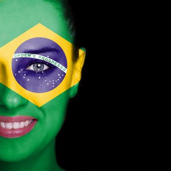 Brazil flag painted on smiling woman face