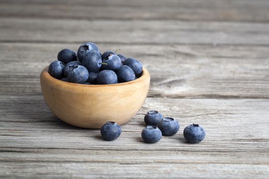 bowl of blueberries on wooden background