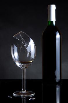 Vine bottle and broken glass on dark background