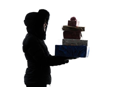 one woman in winter coat carrying christmas gifts silhouette on white background