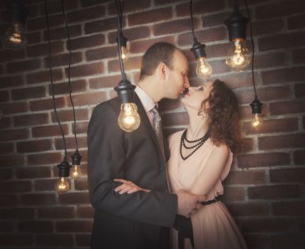 loving couple in the background of walls from a brick and light bulbs