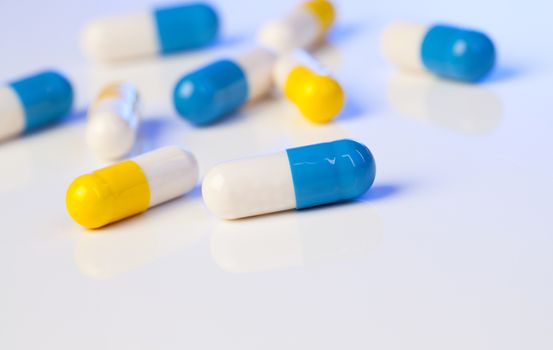 Colorful medical capsules on white background.