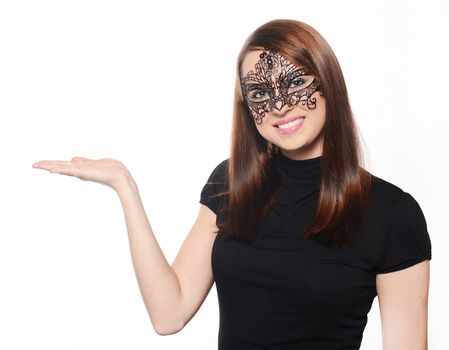 Beautiful woman in carnival mask pointing over white background