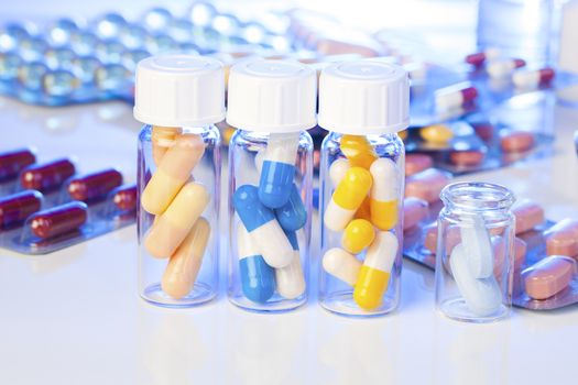 Colorful medical capsules in bottle, on white background.