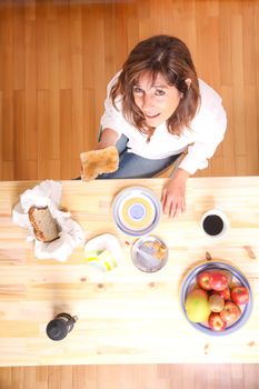 Portrait of a beautiful mature woman sitting in the kitchen. 