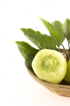 Sweet pepper with green leaves in straw Dish.