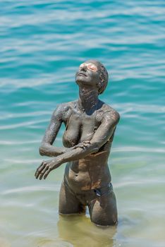 one caucasian woman applying dead sea mud body care treatment in jordan