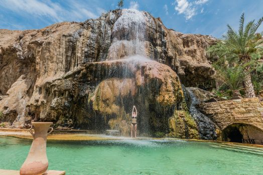 one woman bathing at ma'in hot springs waterfall in jordan middle east