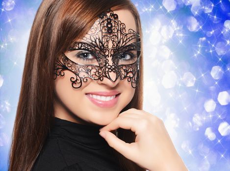 Beautiful woman in carnival mask over blue background