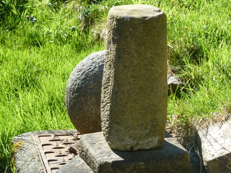 Old brown stone sculpture with a bright green grass background