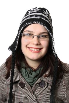 Young woman smiling on a white background wearing a wool hat and scarf 