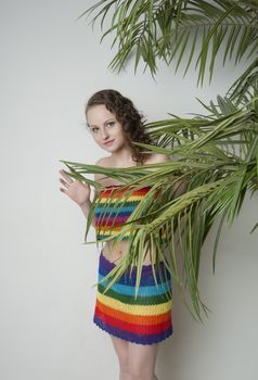 woman in a rainbow clothing under a palm tree in the Studio