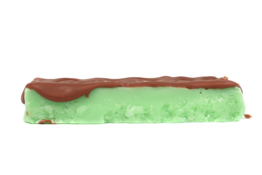 Green fudge bar in mint flavor covered in chocolate drizzle on a white background