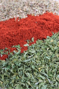 Close up of three different spices, being paprika, parsley flakes and oregano