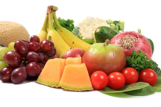 Group of colorful fruits and vegetables like grapes, bananas, and cauliflower on a white background