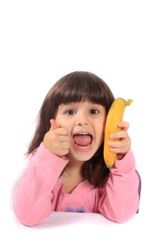 Young little girl giving the thumbs up for healthy eathing with a banana