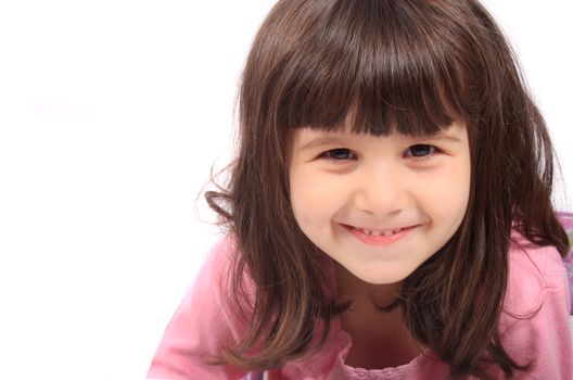 Close up of little four year old brunette girl smiling on a white background