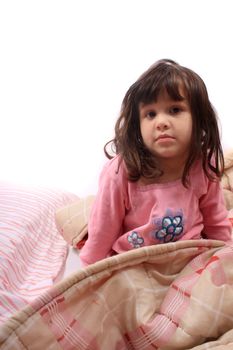 Sleepy little girl just waking up in bed cozy with blanket and messy hair