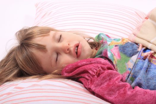Cute little girl laying in bed sleeping cozy on her pillow and in her blanket 