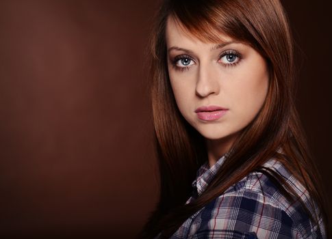 Beautiful brunette posing over brown background