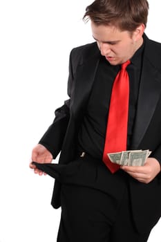 Businessman holding a few dollars and looking at  an empty pocket
