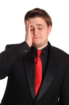 Young stressed business man with headache wearing a black formal suit and red tie on a white background