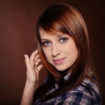 Beautiful brunette posing over brown background