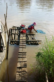 HONG NGU, VIET NAM NOVEMBER 12:Beautiful landscape of people washing clothes on the float on river under sunlight in Hong Ngu, VietNam on November 12, 2013