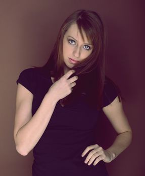 Beautiful brunette posing over brown background