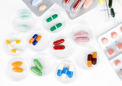 Colorful medical capsules in Petri dishes. Laboratory concept.