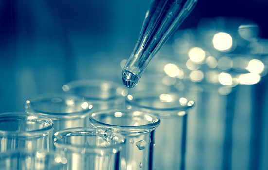 Pipette adding fluid to one of several test tubes