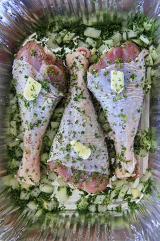 Turkey leg on steel board with herbs