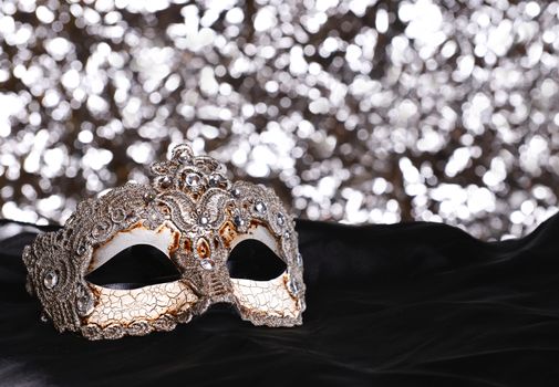 Silver carnival mask on bokeh background