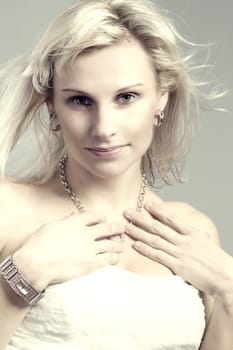 studio portrait of beautiful woman with white dress and waving hair