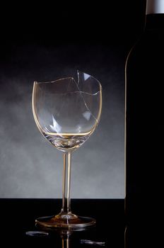 Vine bottle and broken glass on dark background