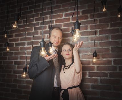 loving couple in the background of walls from a brick and light bulbs