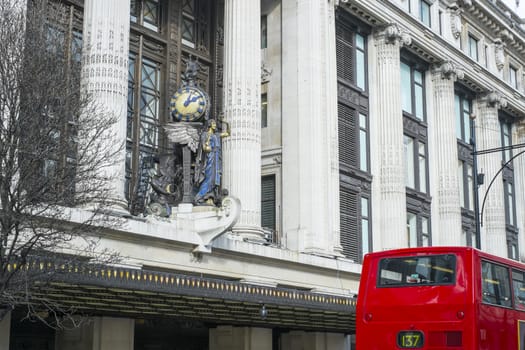 LONDON, UK - MARCH 14: Facade of famous department store Selfridges, with statue of angel holding clock. March 01, 2014 in London.