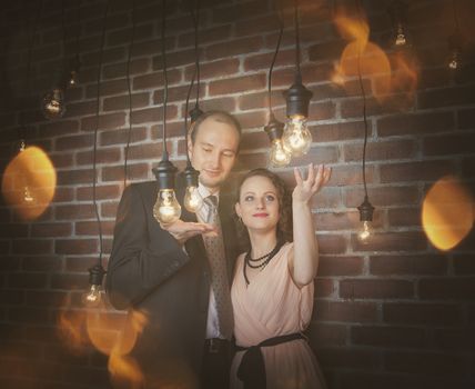 loving couple in the background of walls from a brick and light bulbs