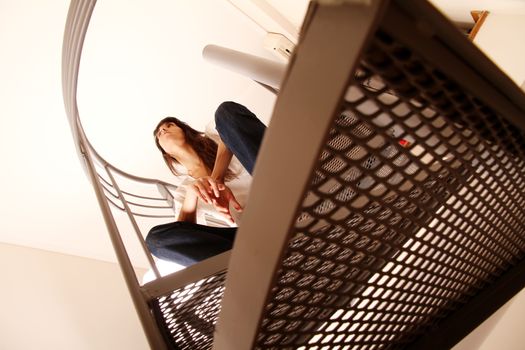 A pensive woman sitting on the stairs.