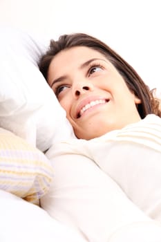 A young girl laying in bed and smiling

