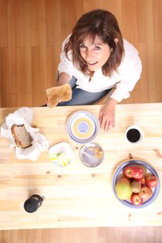 Portrait of a beautiful mature woman sitting in the kitchen. 