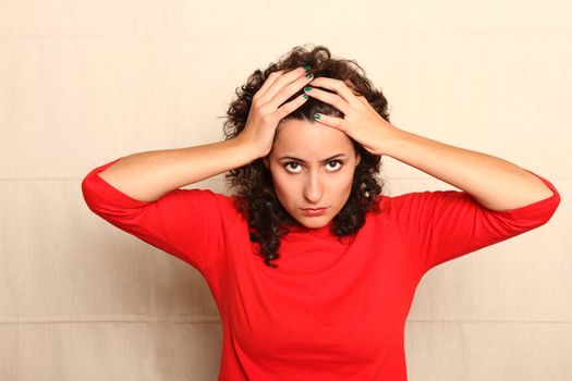 A worried woman holding her head.