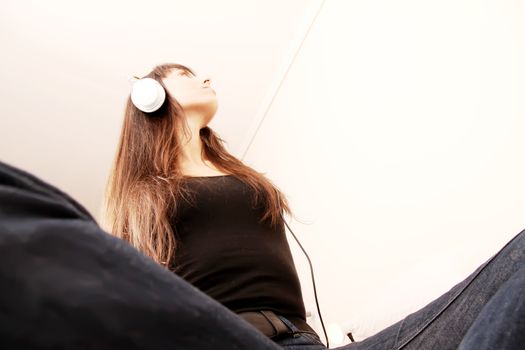 A young woman to Music with headphones.