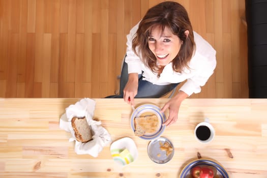 Portrait of a beautiful mature woman sitting in the kitchen. 